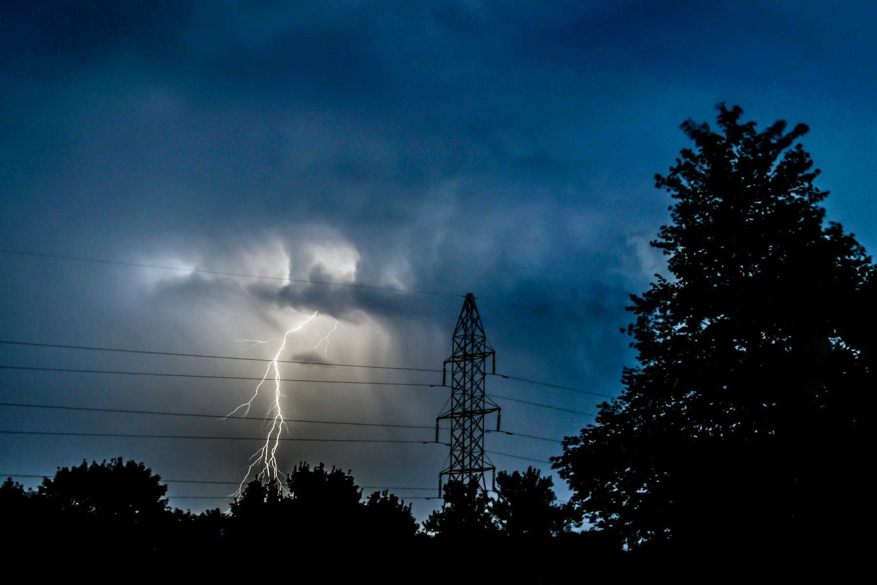 Lightning over electric transmission towers at night