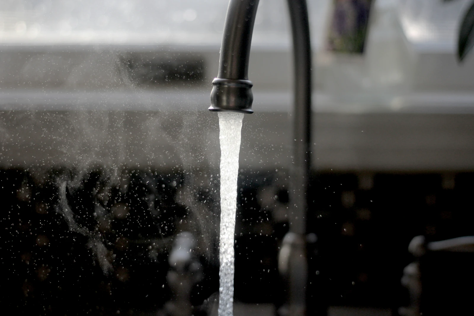 Water running from a kitchen faucet into a sink
